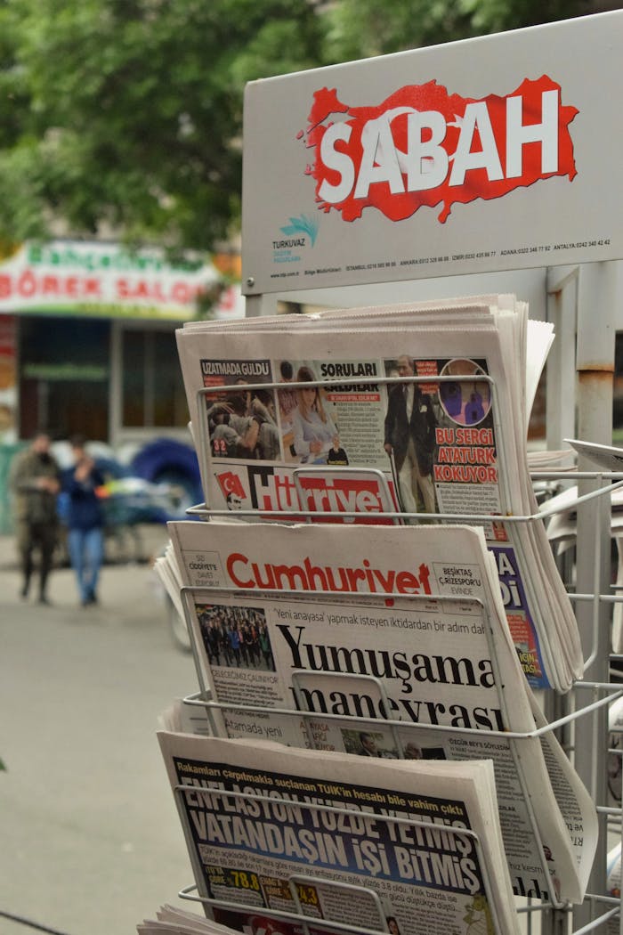 Outdoor rack displaying Turkish newspapers like Sabah and Cumhuriyet.